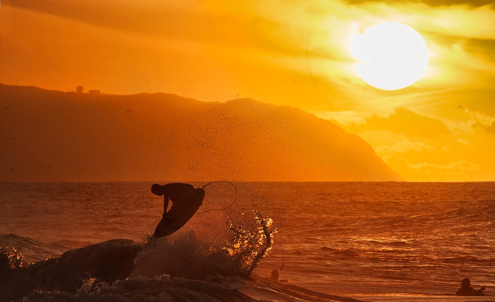 Julian Wilson compondo o famoso pôr-do-sol do Hawaii com seu tradicional shove it reverse.